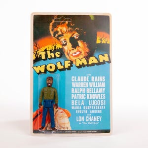 May include: A vintage action figure of "The Wolf Man" movie, packaged on a retro card. The card features the movie title and cast, with a figure of the Wolf Man in a green shirt and blue pants.