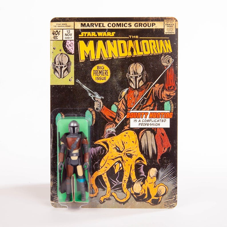 May include: A vintage Star Wars: The Mandalorian action figure on its original comic book-style packaging. The packaging features a comic book cover with the Mandalorian and the text "BIG PREMIERE ISSUE". The figure is in a green plastic blister pack.