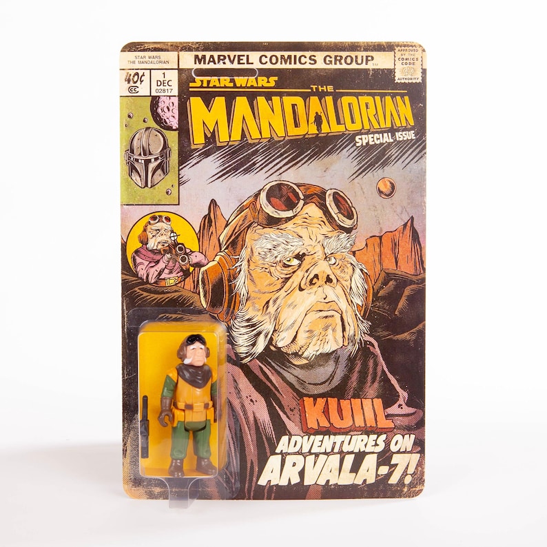 May include: A vintage Star Wars comic book featuring "The Mandalorian" and a Kuill action figure. The comic cover has a brown and yellow color scheme with the text "KUIIL Adventures on Arvala-7!" and the Marvel Comics Group logo.