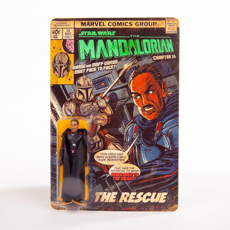 May include: A vintage-style Star Wars: The Mandalorian comic book cover with a Moff Gideon action figure. The comic features illustrations of Mando and Moff Gideon, with text that reads "The Rescue". The action figure is in a clear plastic case.
