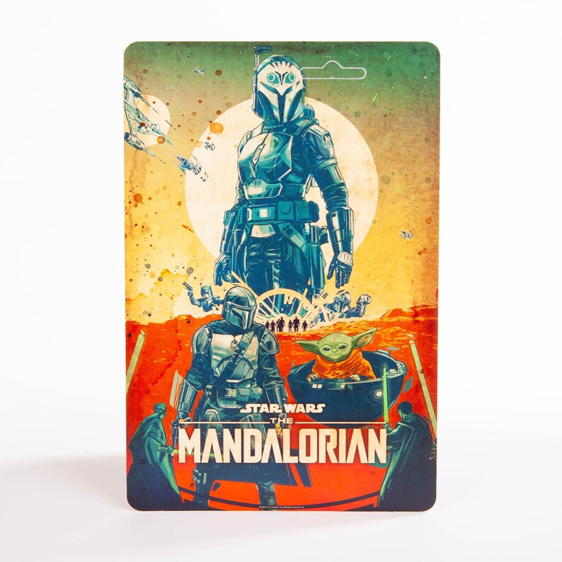 May include: A Star Wars: The Mandalorian action figure card featuring illustrations of characters from the series. The card has a green and orange background with the text "STAR WARS THE MANDALORIAN". The characters include the Mandalorian and Grogu.