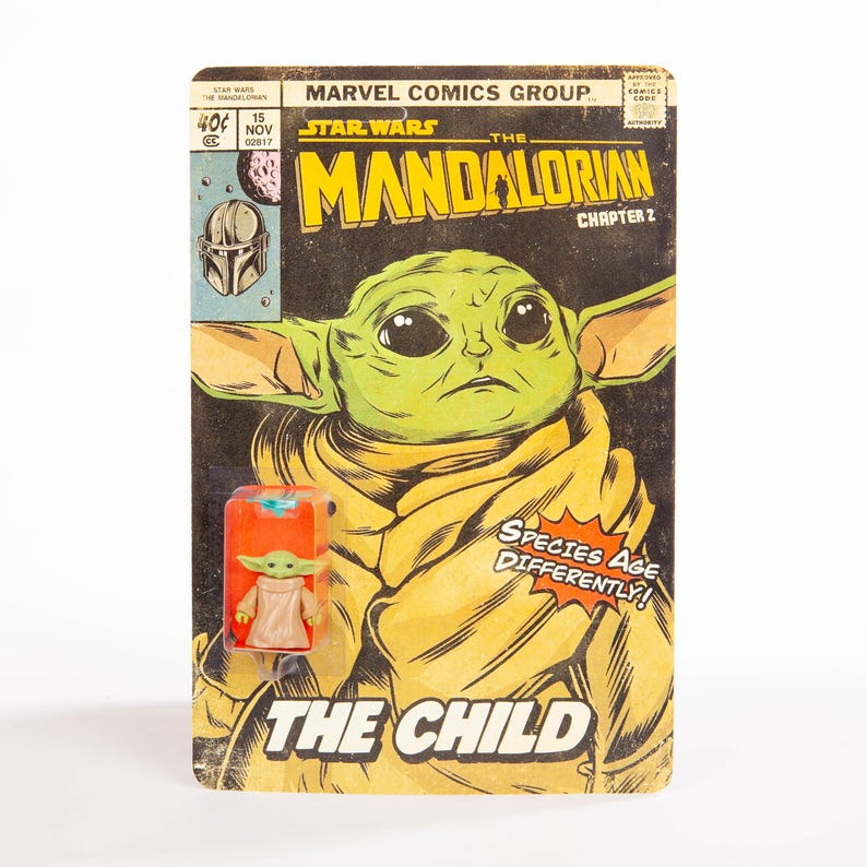 May include: A vintage-style comic book cover featuring The Child from Star Wars: The Mandalorian. The cover art showcases a large image of The Child, with text that reads "The Mandalorian" and "The Child". A small action figure of The Child is attached.