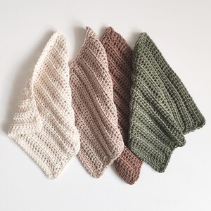 May include: Four handmade crochet washcloths in varying neutral colors: cream, light brown, medium brown, and olive green. Each washcloth features a diagonal ribbed pattern and a triangular shape, perfect for kitchen or bathroom use.