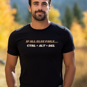 Puede incluir: Una camiseta negra con el texto "IF ALL ELSE FAILS... CTRL + ALT + DEL" en letras marrones.
