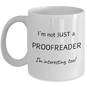 May include: White ceramic mug with a curved handle. The mug features the text "I'm not JUST a PROOFREADER I'm interesting, too!" in black, making it a perfect gift for proofreaders and editors.