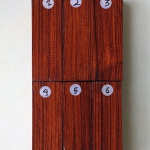 May include: Six wood samples numbered 1 through 6. The samples are arranged in two rows of three. The wood is a dark reddish-brown color with a grain pattern.