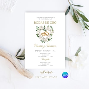 Op de afbeelding: Een witte uitnodigingskaart met gouden tekst en accenten. De kaart bevat de tekst "Bodas de Oro" en de namen "Carmen y Francisco". Een bloemenhart met gouden trouwringen staat in het midden. De uitnodiging is voor een bruiloft.