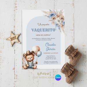Puede incluir: Invitación a baby shower con temática de vaquero. La invitación presenta un osito de peluche con sombrero de vaquero y overoles, sosteniendo globos. El texto dice "Un pequeña VAQUERITO viene en camino!" e incluye detalles del evento.