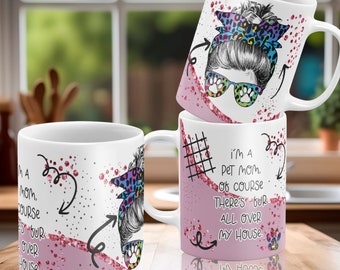 May include: Two white ceramic mugs with pink glitter and a black and white illustration of a woman with a messy bun and sunglasses. The text on the mugs reads "I'm a pet mom. Of course there's fur all over my house."
