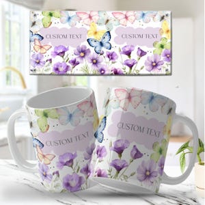 Op de afbeelding: Witte keramische mokken en een rechthoekig canvas met een vlinder- en bloemenontwerp. Het ontwerp bevat vlinders in verschillende kleuren, paarse bloemen en de tekst "CUSTOM TEXT" op een lichtpaarse wolk-vormige achtergrond.