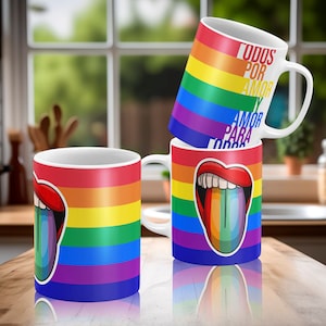 May include: Three white ceramic mugs with rainbow stripes and a rainbow tongue design. The mugs have the text "TODOS POR AMOR AMOR PARA TODOS" on one mug.