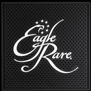 Pu&ograve; includere: Tappetino da bar nero con superficie strutturata. Il testo bianco "Eagle Rare" &egrave; visualizzato in una sceneggiatura stilizzata, con una testa d'aquila e stelle sopra la parola "Eagle".