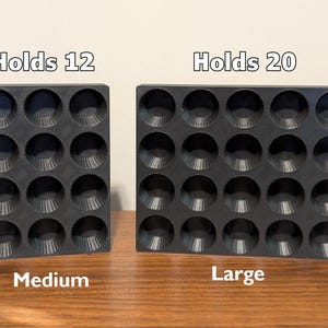K&ouml;nnte beinhalten: Zwei schwarze Silikon-Muffinbackformen. Die Form links ist mit "Holds 12" und "Medium" beschriftet. Die Form rechts ist mit "Holds 20" und "Large" beschriftet.