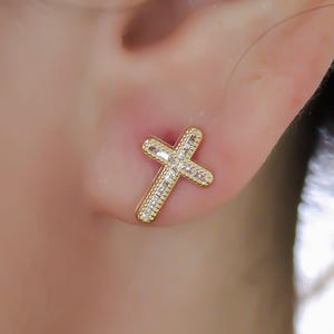 May include: Gold cross earrings with small clear cubic zirconia stones.