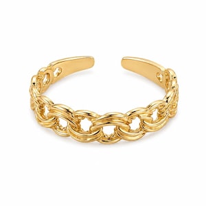 May include: A gold-colored ring with a chain link design. The open ring features a series of interconnected oval links, creating a textured appearance. The ring is designed to be adjustable, with an open band.