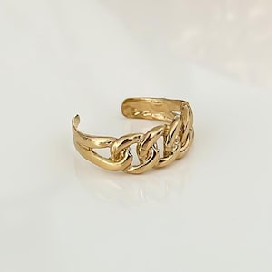 May include: Gold chain link toe ring. The ring is made of a thick, chunky chain link design.
