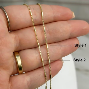 Puede incluir: Dos cadenas de color dorado con peque&ntilde;as cuentas met&aacute;licas cil&iacute;ndricas espaciadas uniformemente. La cadena etiquetada como Style 1 tiene cuentas cil&iacute;ndricas lisas y pulidas, mientras que la cadena Style 2 presenta cuentas texturizadas.
