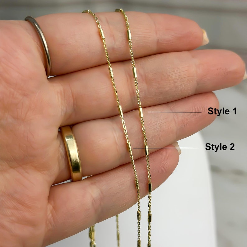 Puede incluir: Dos cadenas de color dorado con peque&ntilde;as cuentas met&aacute;licas cil&iacute;ndricas espaciadas uniformemente. La cadena etiquetada como Style 1 tiene cuentas cil&iacute;ndricas lisas y pulidas, mientras que la cadena Style 2 presenta cuentas texturizadas.