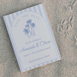 May include: Save the date card with blue and white stripes. The card features a drawing of palm trees and the text "Save the Date" at the top. The text "for the wedding of Amanda & Oliver" is below the palm trees. The date "August 11, 2025" and location "Honolulu, Hawaii" are listed below the names. The text "formal invitation to follow" is at the bottom of the card.