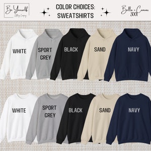 K&ouml;nnte beinhalten: Eine Auswahl an Sweatshirts in verschiedenen Farben, darunter Wei&szlig;, Sportgrau, Schwarz, Sand und Marineblau. Das Bild zeigt die Sweatshirts mit den Farbbezeichnungen darunter. Der Text "Color Choices: Sweatshirts" steht oben.