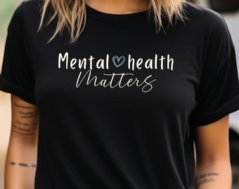 Op de afbeelding: Zwart T-shirt met witte tekst die "Mental health matters" zegt met een blauw hart symbool.