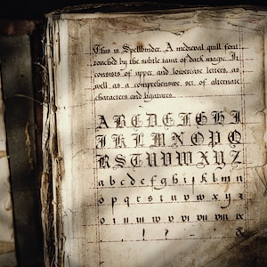 May include: An old book with a gothic font displayed on its pages. The text describes the font as "Spellbinder," a medieval quill font. The alphabet is shown in upper and lowercase, with ligatures.