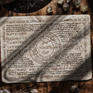 May include: Aged parchment with detailed, stylized text and a central circular design. The paper has a worn, antique appearance, with dark brown ink. The background includes gemstones and metal objects, suggesting a mystical or fantasy theme.