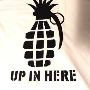 May include: White t-shirt with black text that reads "Party Popper" and a black silhouette of a pineapple grenade with the text "Up in Here" below it.