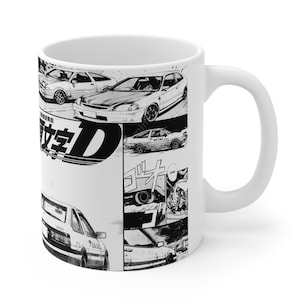 Op de afbeelding: Witte keramische mok met zwart-wit manga-stijl illustraties van auto's en Japanse tekst. De mok heeft een gebogen handvat en een glanzende afwerking.