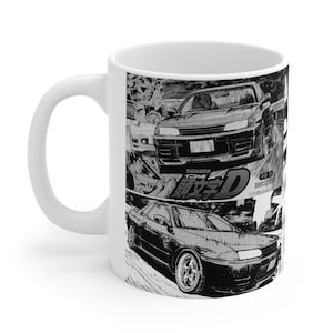 Op de afbeelding: Witte keramische mok met een zwart-wit manga-stijl ontwerp dat een autoracescène uitbeeldt. De mok heeft een gebogen handvat en een glanzende afwerking. Het ontwerp bevat Japanse tekst en afbeeldingen van auto's.
