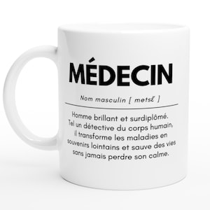 Peut inclure: Mug en céramique blanche avec le mot "MÉDECIN" en gras noir. Une définition en français est présente en dessous. La tasse a une anse incurvée et est posée sur un fond blanc.