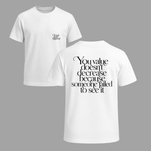 May include: Two white t-shirts. One shirt has the text "Oops! Shit Happened" on the front and the other has the text "You value doesn't decrease because someone failed to see it" on the back in black.