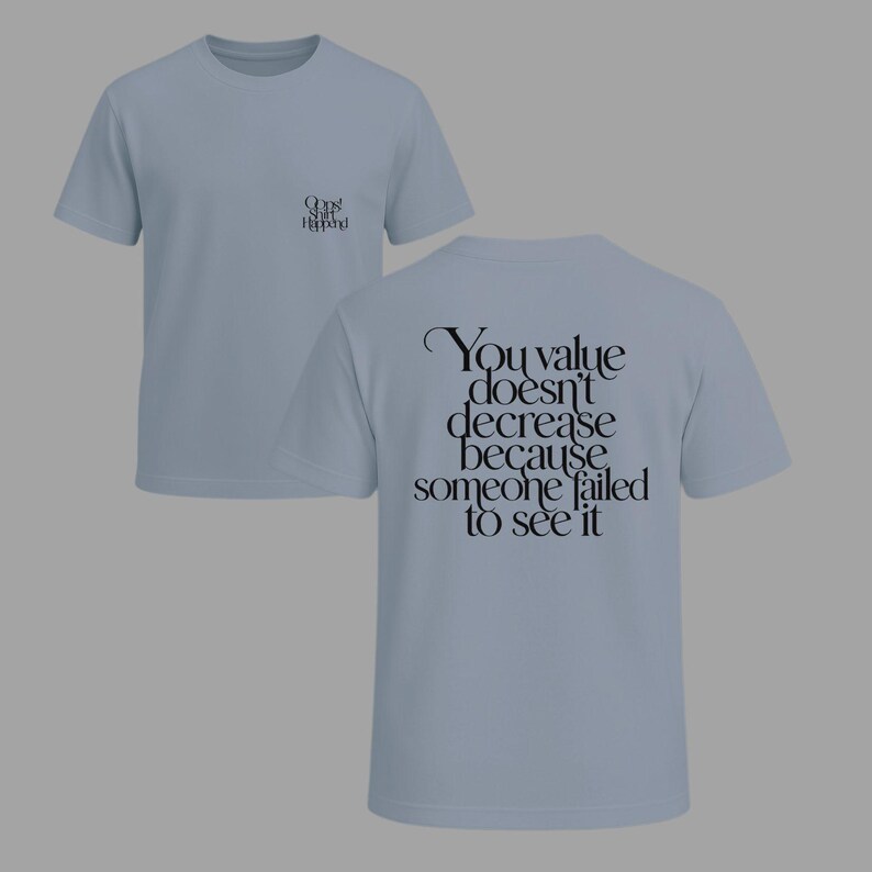 May include: Two light blue t-shirts. One shirt has the text "Oops! Shit Happens!" on the front. The other shirt has the text "You value doesn't decrease because someone failed to see it" on the back.