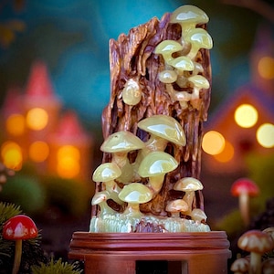 May include: A decorative sculpture featuring a cluster of light green mushrooms growing on a brown wooden base. The mushrooms have a translucent appearance, and the wooden base has a natural, textured look. The sculpture is set against a blurred background.