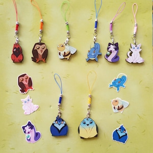 Puede incluir: Un conjunto de 12 llaveros coloridos con varios diseños de animales de dibujos animados, incluyendo búhos, gatos, abejas y dragones. Los llaveros están hechos de madera y tienen un lazo de cuerda para sujetarlos a las llaves o las bolsas.