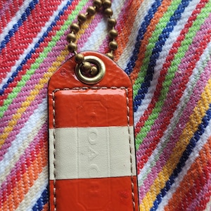 Coach Patent Stripped Leather Hang Tag with Vintage Brass Chain Color Orange and White Gold-Plated Hardware Size large 2.5&#39;&#39;