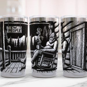 May include: Three stainless steel travel mugs with black and white illustrations. One mug features a sign that reads "EW, PEOPLE." Another shows a Bigfoot figure relaxing with a mug. The third mug depicts Bigfoot near a cabin door.