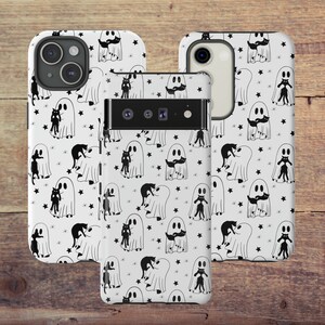 May include: Two white phone cases with a black and white pattern of ghosts and cats. The cases have a white background with black stars and black outlines of ghosts and cats. The ghosts are holding cats in their arms. The cases are for a phone with a triple camera lens.