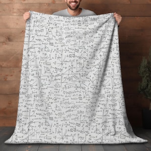 May include: A white blanket featuring a repeating pattern of mathematical equations, formulas, and diagrams in black ink. The blanket is held up, showcasing the full design. The equations include trigonometric functions, integrals, and other calculus concepts.