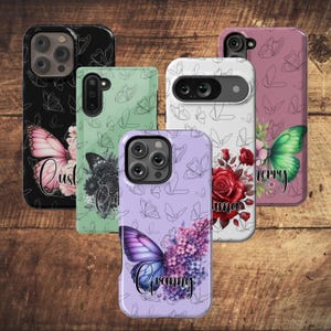 May include: Five different phone cases with butterfly designs. The cases are in various colors, including black, green, purple, white, and pink. Each case features a different butterfly design and a personalized name, including "Cust", "Oma", "Granny", and "Cherry".