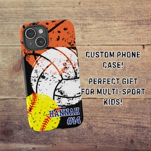 May include: A black phone case with a distressed design featuring a basketball, volleyball, and softball. The case has the name "HANNAH" and the number "#14" printed on it.