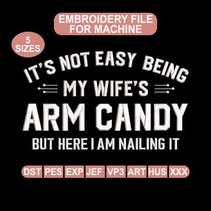 Könnte beinhalten: Schwarze digitale Stickdatei mit dem Text "IT'S NOT EASY BEING MY WIFE'S ARM CANDY BUT HERE I AM NAILING IT". Das Design enthält die Wörter "EMBROIDERY FILE FOR MACHINE" und "5 SIZES".
