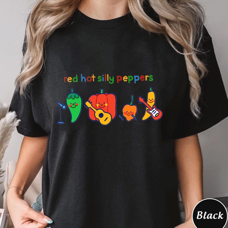 Pu&ograve; includere: Maglietta nera con il testo "red hot silly peppers" in colori arcobaleno. Il testo &egrave; sopra una linea di cinque peperoni dei cartoni animati che suonano strumenti musicali.