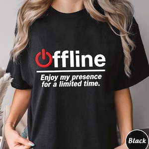 Może przedstawiać: Czarny t-shirt z napisem "offline" w kolorze białym, z czerwoną ikoną przycisku zasilania. Poniżej znajduje się fraza "Enjoy my presence for a limited time." Koszulka jest w jednolitym czarnym kolorze.