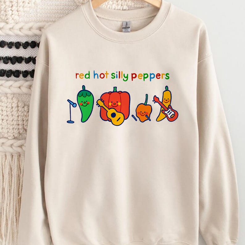 Pu&ograve; includere: Una felpa beige con la scritta "red hot silly peppers" stampata sul davanti. Il testo &egrave; in colori arcobaleno. Ci sono cinque peperoni dei cartoni animati che suonano strumenti musicali.