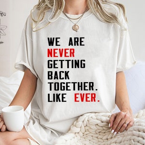 May include: White t-shirt with black text that reads "We are never getting back together. Like ever."