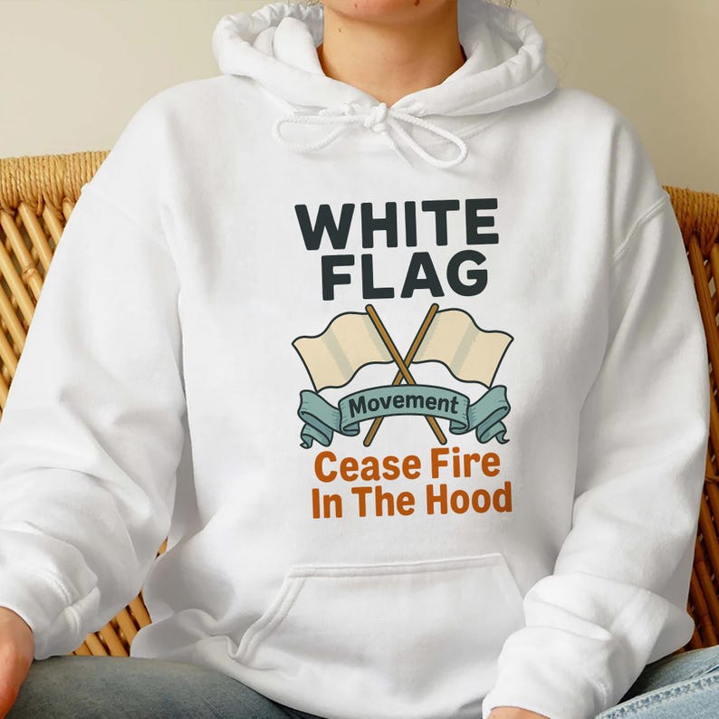 May include: White hooded sweatshirt with the text "WHITE FLAG" above an illustration of two crossed flags and the words "Movement" and "Cease Fire In The Hood". The sweatshirt is white.