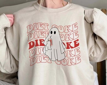 Op de afbeelding: Een beige sweatshirt met een spook dat een blikje Diet Coke vasthoudt. De tekst "DIET COKE" wordt herhaald in een retro-lettertype.
