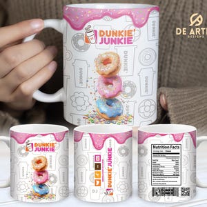May include: White ceramic mug with a pink and white design featuring a stack of donuts and the text "Dunkie Junkie".