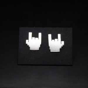 May include: A pair of silver earrings shaped like a hand making the rock and roll hand gesture.